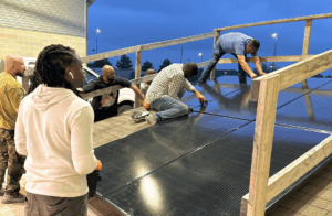 People install solar panels on inclined platform.