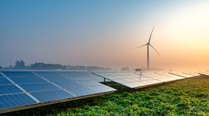Solar panels and wind turbine at sunrise